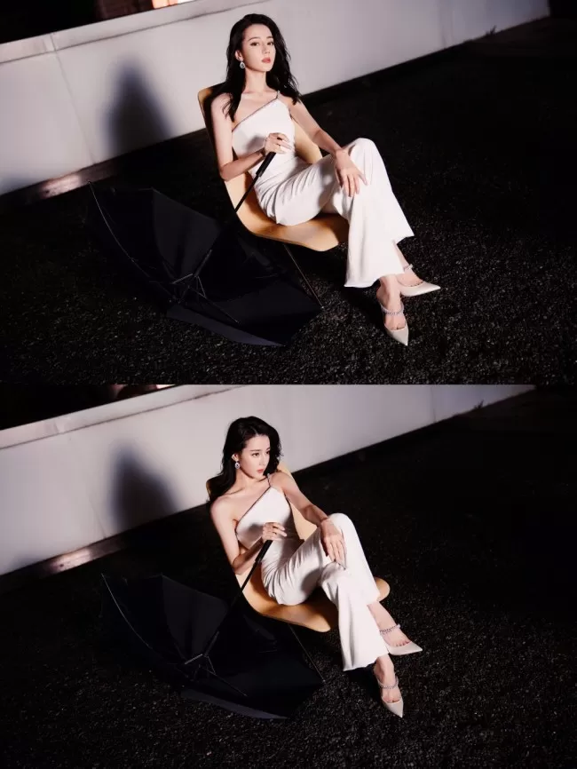 热巴穿斜肩连体裤撑黑伞 眼神霸气酷飒十足