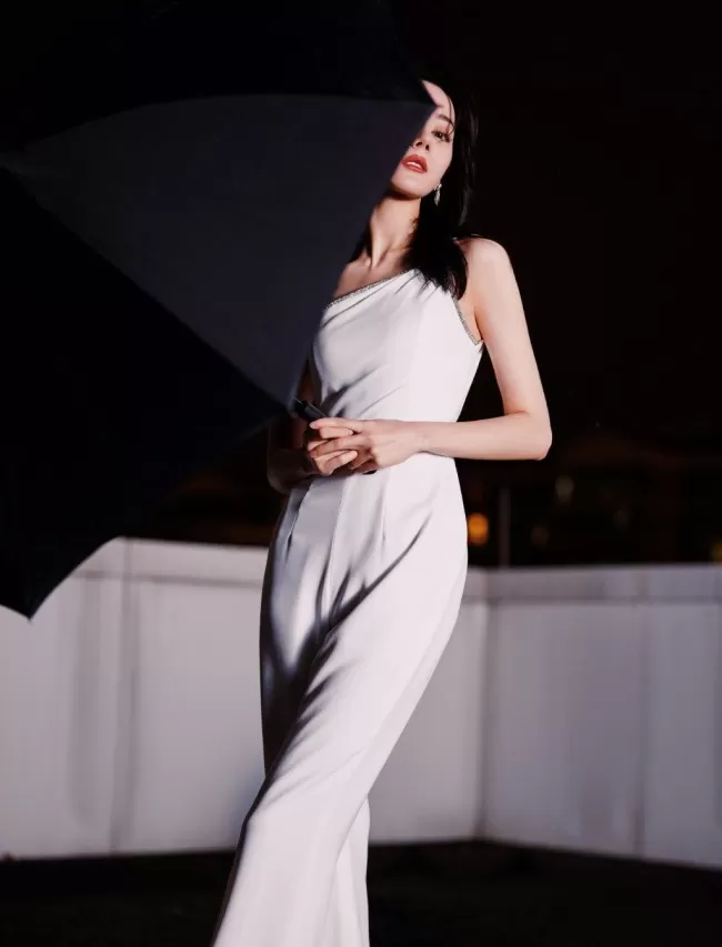 热巴穿斜肩连体裤撑黑伞 眼神霸气酷飒十足