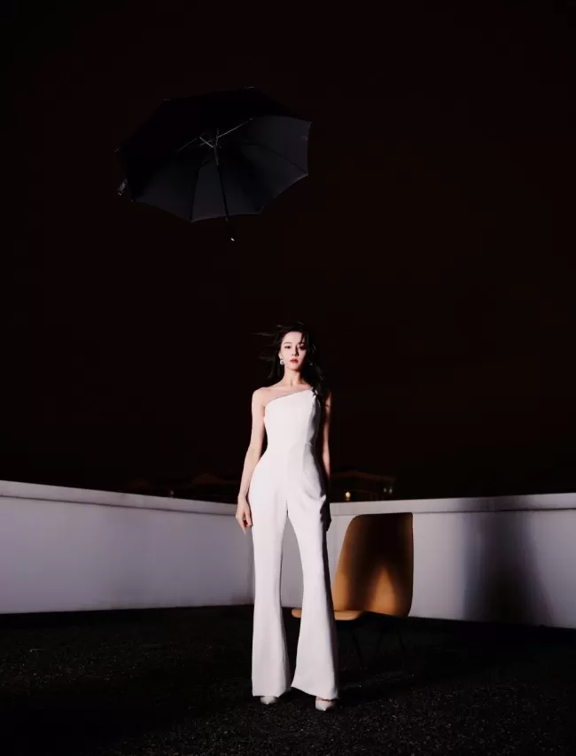 热巴穿斜肩连体裤撑黑伞 眼神霸气酷飒十足